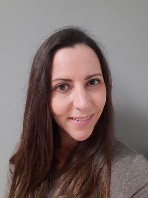 professor wearing a gray shirt in front of a gray backdrop